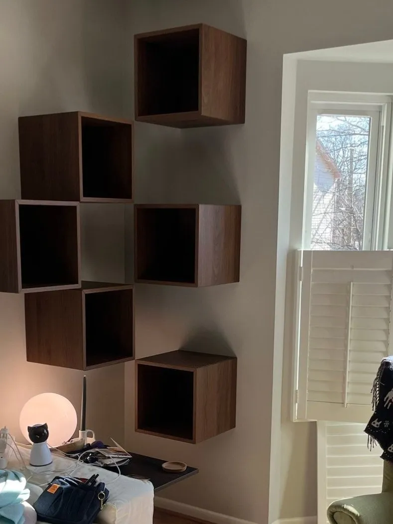 Floating walnut cube shelves on a living-room wall