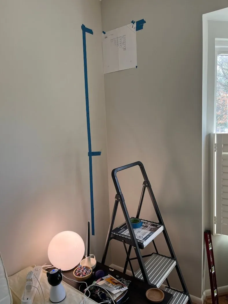 Blue-tape layout for cube shelves on a corner wall