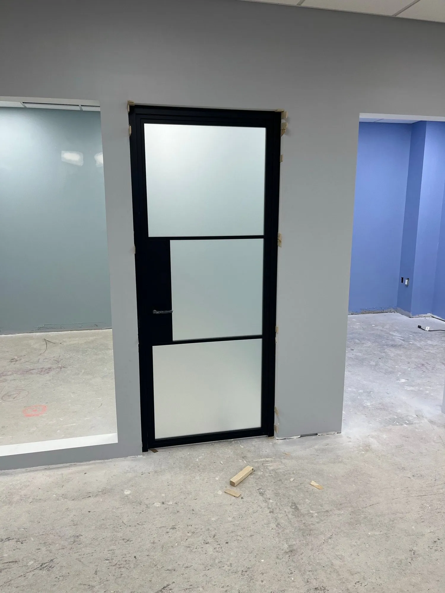 Black-framed frosted-glass office door installed